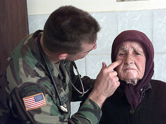 A US Army physician’s assistant provides medical assistance to an elderly Serbian woman in Kosovo.
