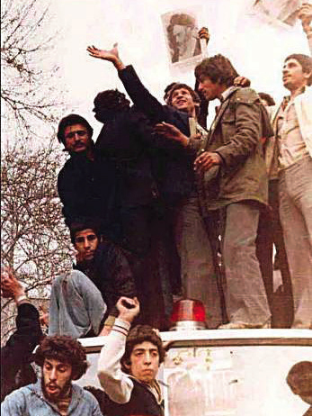 Protesters hold up images of Ayatollah Khomeni during the 1979 revolution